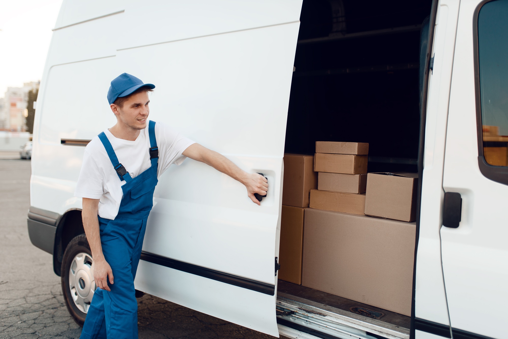 Deliveryman in uniform closing car door, delivery